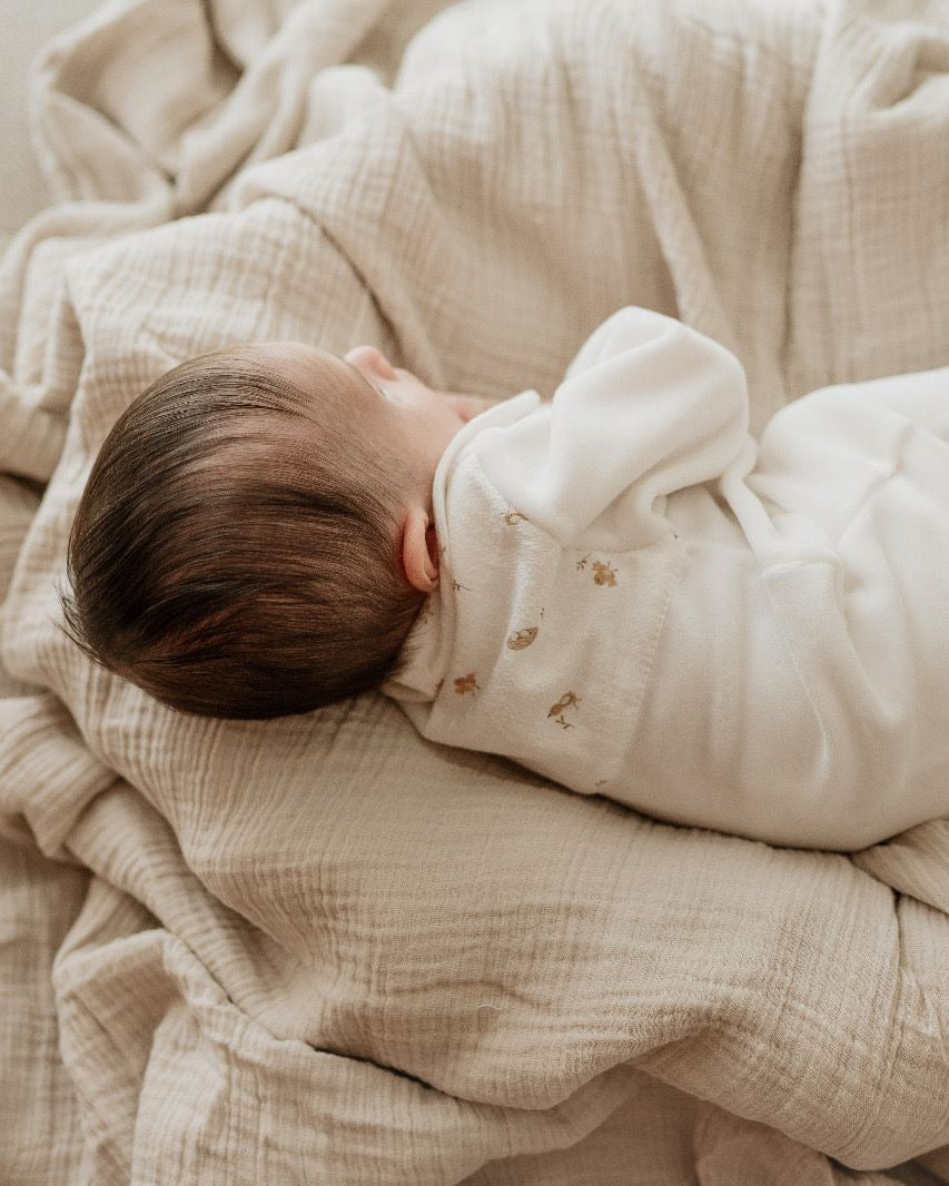 Bebé com o babygrow creme de passarinhos